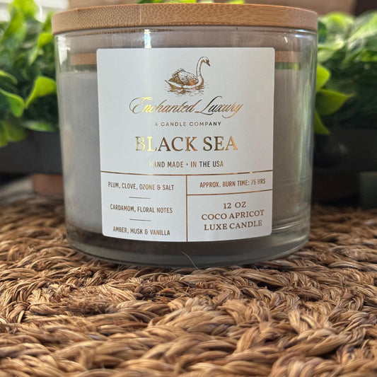 a jar of black sea candle sitting on a table